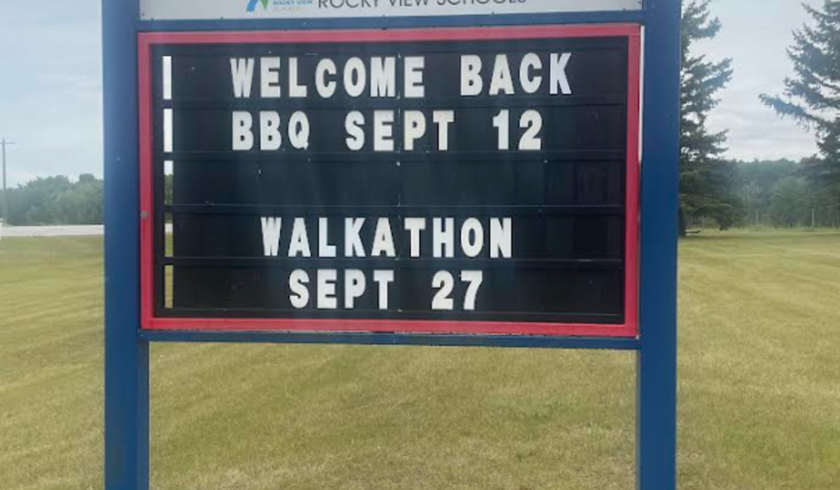 Westbrook School sign. Blue trim, black background and white lettering. Sign reads Welcome Back BBQ Sept. 12, Walkathon Sept. 27